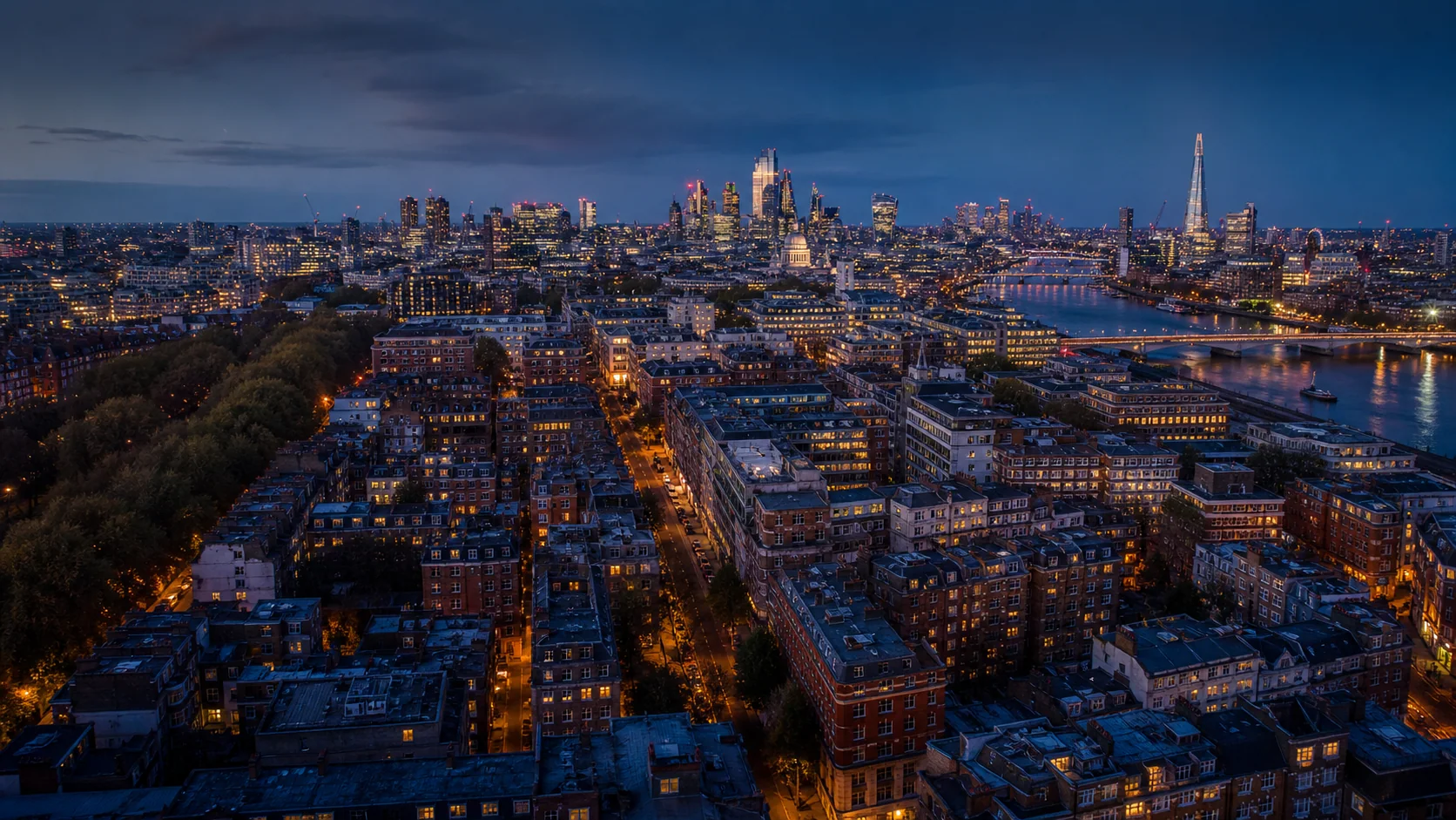 Aerial view across London homes and the city at blue hour.